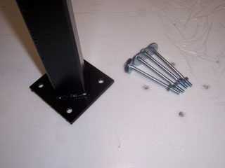 Metal post base with bolts on white surface